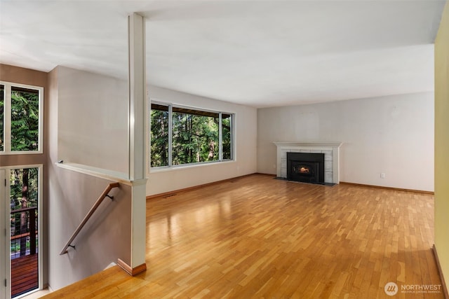 540 SW Fernwood St, Issaquah, WA 98027 - unfurnished living room with light wood-style floors, a fireplace with flush hearth, and baseboards