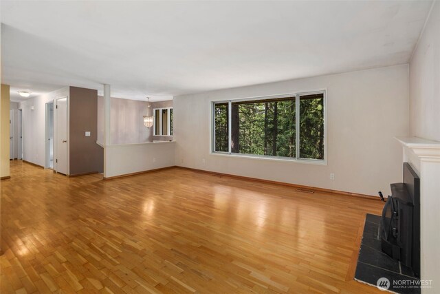 540 SW Fernwood St, Issaquah, WA 98027 - unfurnished living room with light wood finished floors, a fireplace, and baseboards