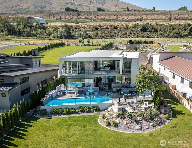 64 Orchard Pl, Orondo, WA 98843 - rear view of house with fence, an outdoor pool, a mountain view, a balcony, and a yard