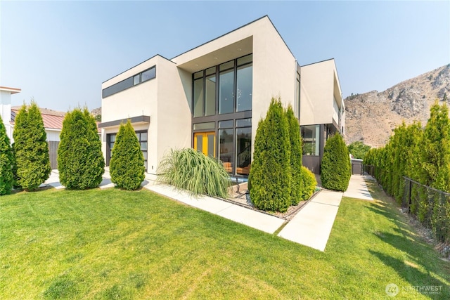64 Orchard Pl, Orondo, WA 98843 - back of house featuring a lawn, fence, and stucco siding