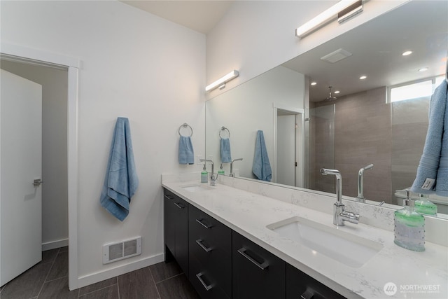 64 Orchard Pl, Orondo, WA 98843 - bathroom featuring tiled shower, double vanity, visible vents, and a sink