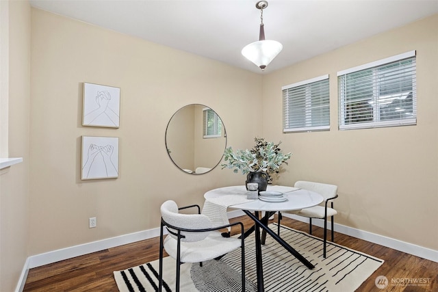 dining space with baseboards, a healthy amount of sunlight, and dark wood-type flooring