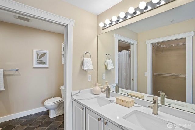 full bathroom featuring toilet, baseboards, a sink, and tile patterned flooring
