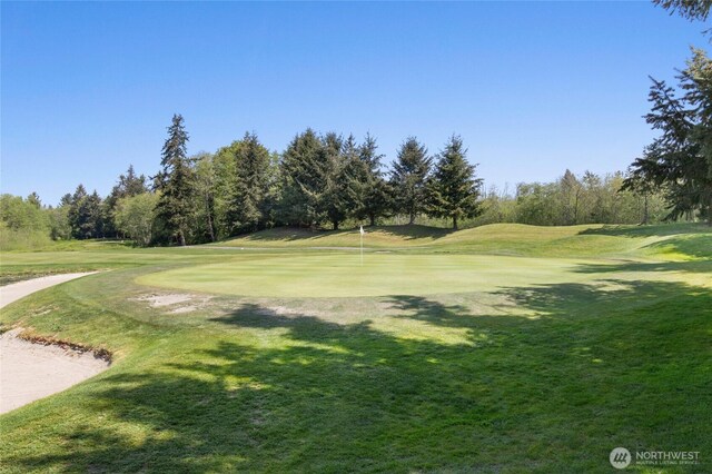 view of home's community with a lawn and view of golf course