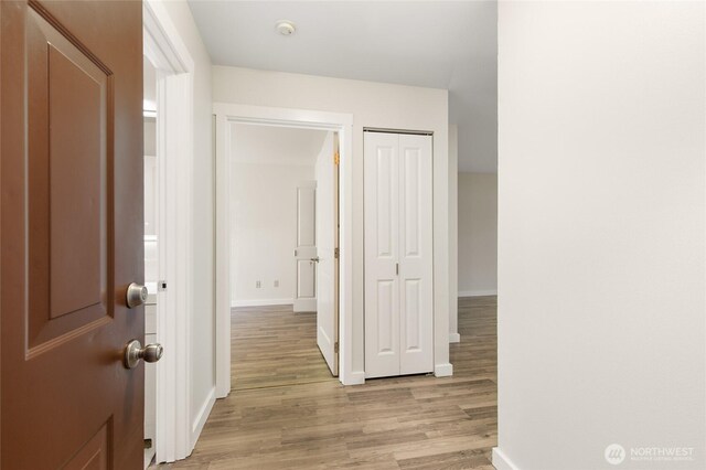 hallway with light wood-style floors and baseboards