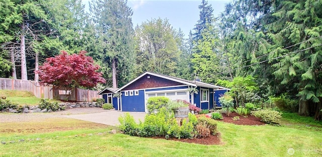 exterior space featuring fence, an attached garage, and driveway