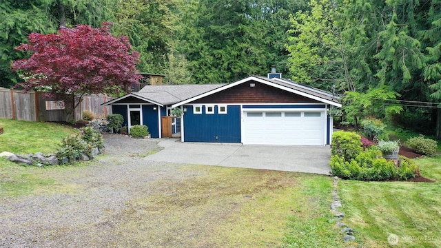view of front of property with fence, driveway, and a front lawn