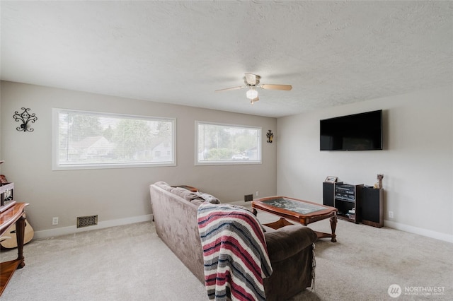 living room with carpet flooring, a textured ceiling, ceiling fan, and visible vents