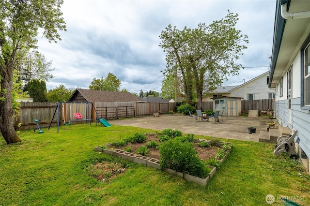 view of yard with a storage shed, a patio area, a fenced backyard, an outdoor structure, and a playground