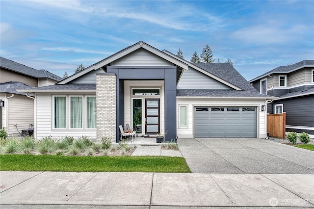 view of front of property with a garage, fence, concrete driveway, and roof with shingles
