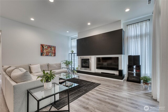living room featuring recessed lighting, visible vents, and wood finished floors