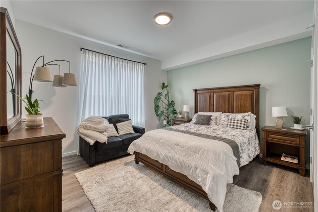 bedroom featuring visible vents and wood finished floors