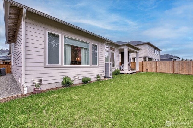 view of front of property featuring fence, central air condition unit, and a front lawn