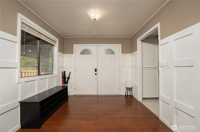 foyer entrance featuring a textured ceiling and wood finished floors