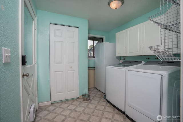 clothes washing area with cabinet space and washing machine and clothes dryer