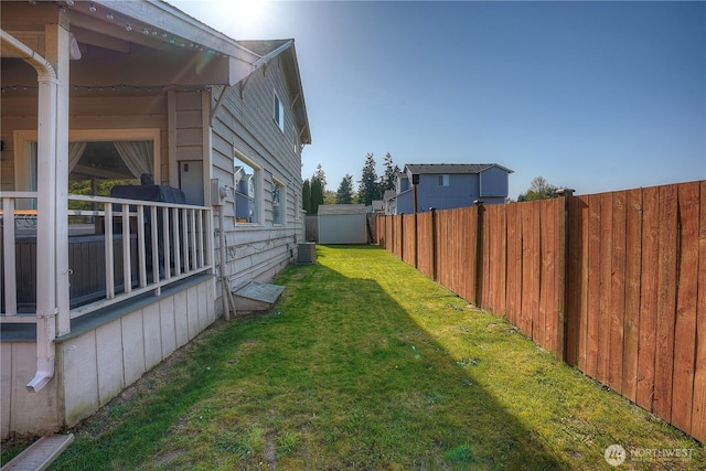 view of yard with an outdoor structure, cooling unit, a fenced backyard, and a shed