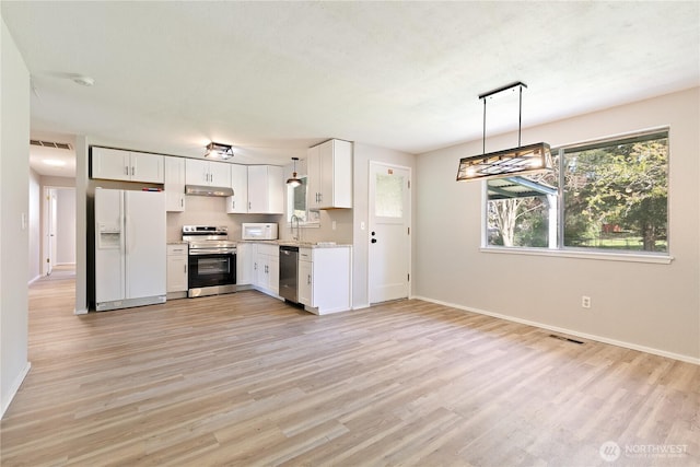 801 141st St S, Tacoma, WA 98444 - kitchen featuring under cabinet range hood, appliances with stainless steel finishes, light wood-style flooring, and visible vents