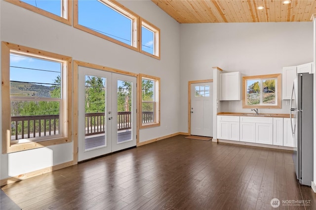 428 Castle Ave, Winthrop, WA 98862 - unfurnished living room with a high ceiling, french doors, dark wood-style floors, wooden ceiling, and recessed lighting