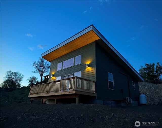 rear view of house featuring central AC unit and a deck