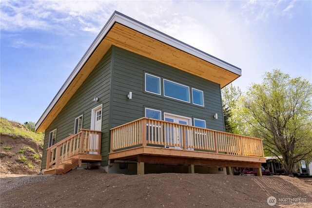 rear view of property featuring a wooden deck