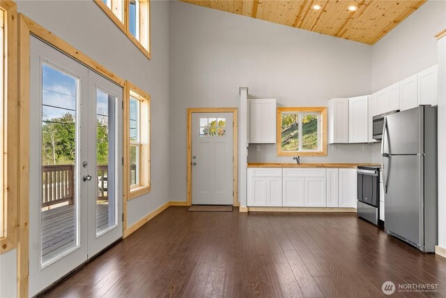 kitchen featuring appliances with stainless steel finishes, french doors, high vaulted ceiling, and white cabinetry