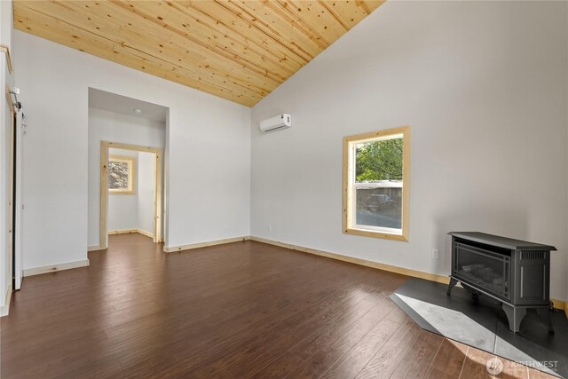 unfurnished living room featuring a wood stove, baseboards, a wall mounted air conditioner, dark wood-style floors, and vaulted ceiling
