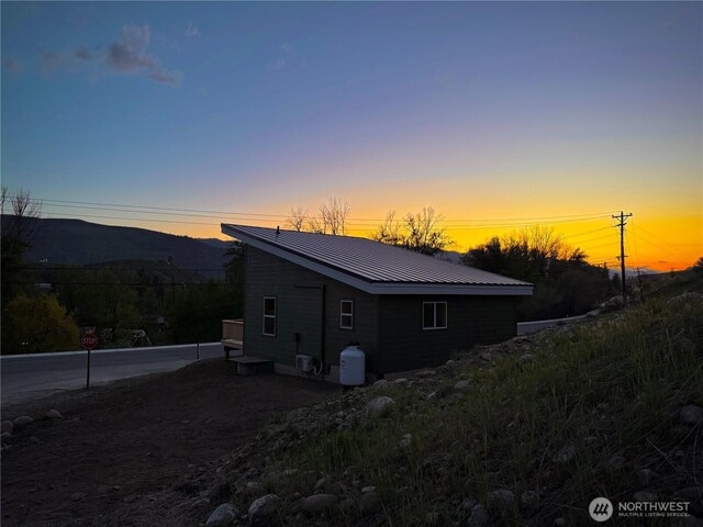 view of side of property with a mountain view and metal roof