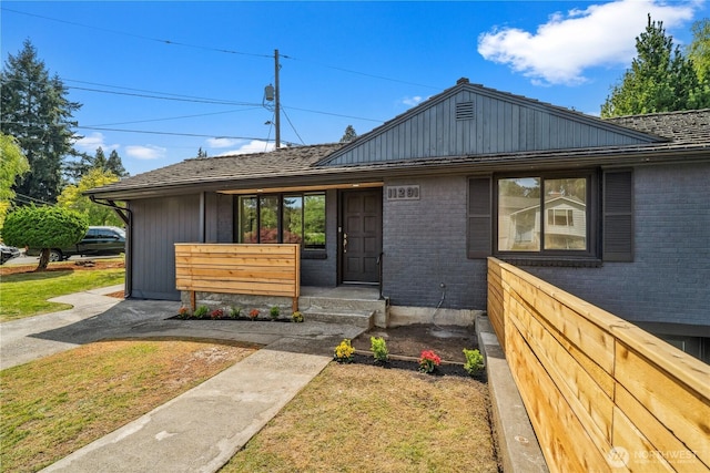 view of front of house featuring a front lawn and brick siding