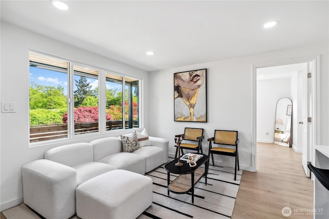 living area featuring light wood-style floors, baseboards, and recessed lighting