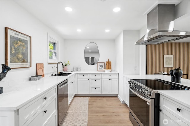 kitchen featuring wall chimney range hood, a sink, light wood-style floors, stainless steel appliances, and recessed lighting