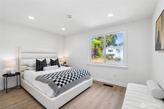 bedroom with baseboards, recessed lighting, wood finished floors, and visible vents