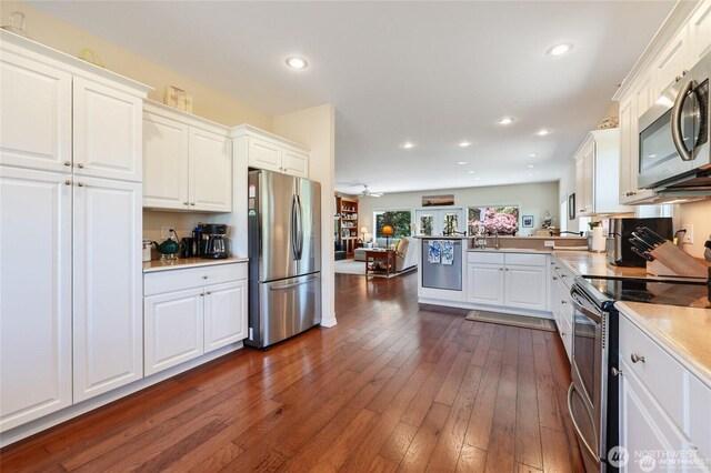 kitchen featuring white cabinets, open floor plan, and appliances with stainless steel finishes