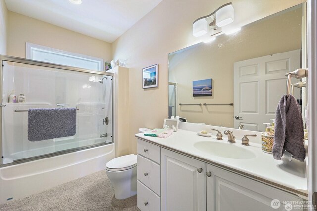 bathroom with vanity, combined bath / shower with glass door, and toilet