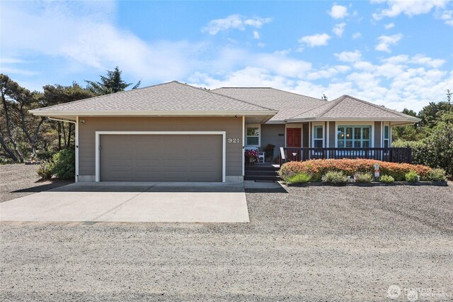 single story home featuring concrete driveway, covered porch, and a garage