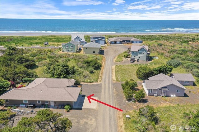 drone / aerial view featuring a beach view and a water view