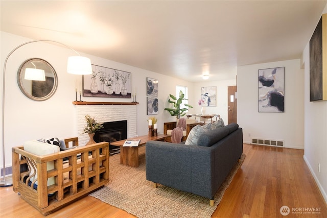 12223 4th Ave NW, Seattle, WA 98177 - living area featuring baseboards, a brick fireplace, wood finished floors, and visible vents