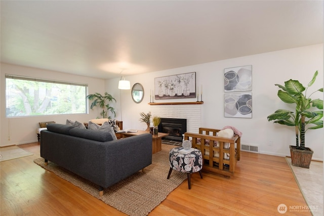 12223 4th Ave NW, Seattle, WA 98177 - living area featuring visible vents, light wood finished floors, a brick fireplace, and baseboards