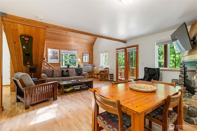 7502 Glacier Spgs, Deming, WA 98244 - dining room with plenty of natural light, light wood-style flooring, lofted ceiling, wood walls, and a glass covered fireplace