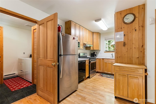 7502 Glacier Spgs, Deming, WA 98244 - kitchen featuring appliances with stainless steel finishes, under cabinet range hood, independent washer and dryer, a baseboard heating unit, and light wood-type flooring