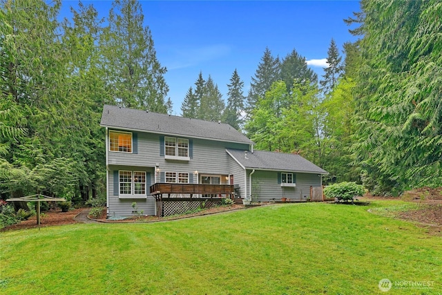 rear view of house featuring a lawn and a wooden deck
