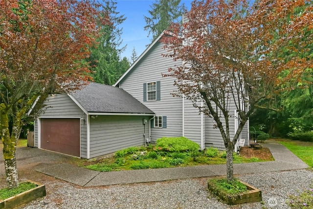 view of home's exterior with a garage and roof with shingles