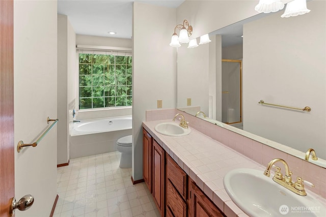 full bathroom with a garden tub, a sink, tile patterned floors, and double vanity
