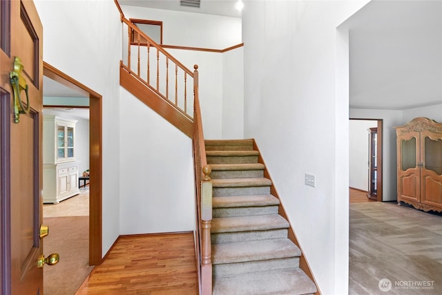 staircase featuring carpet floors and visible vents
