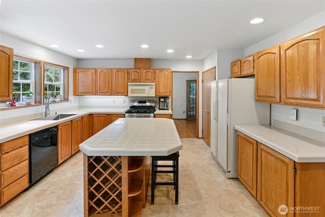 kitchen featuring a sink, recessed lighting, a kitchen island, and white appliances