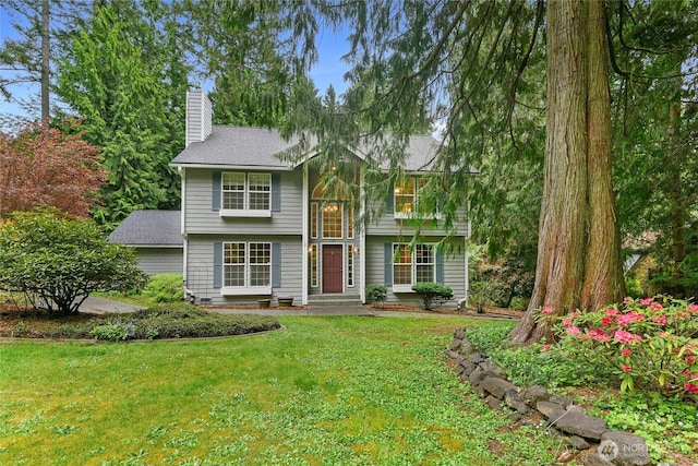 view of front of property with a chimney and a front yard