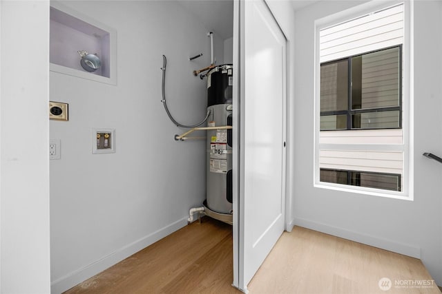 interior space with washer hookup, light wood-style flooring, water heater, baseboards, and electric dryer hookup