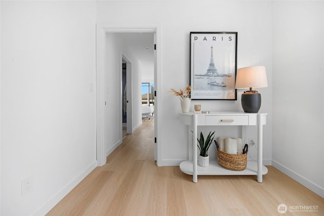hall featuring baseboards and wood finished floors
