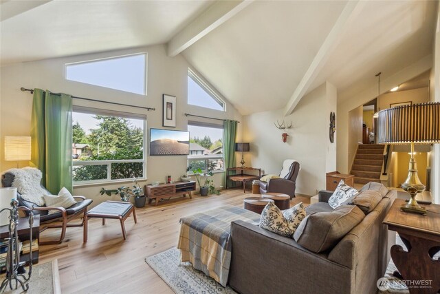 living room featuring stairway, high vaulted ceiling, beamed ceiling, and light wood-type flooring