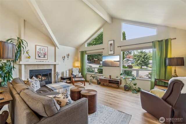 living room with high vaulted ceiling, beamed ceiling, wood finished floors, and a tile fireplace