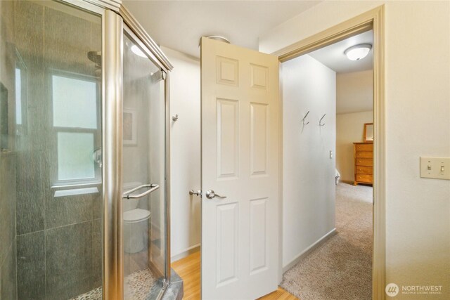 bathroom with baseboards and a stall shower